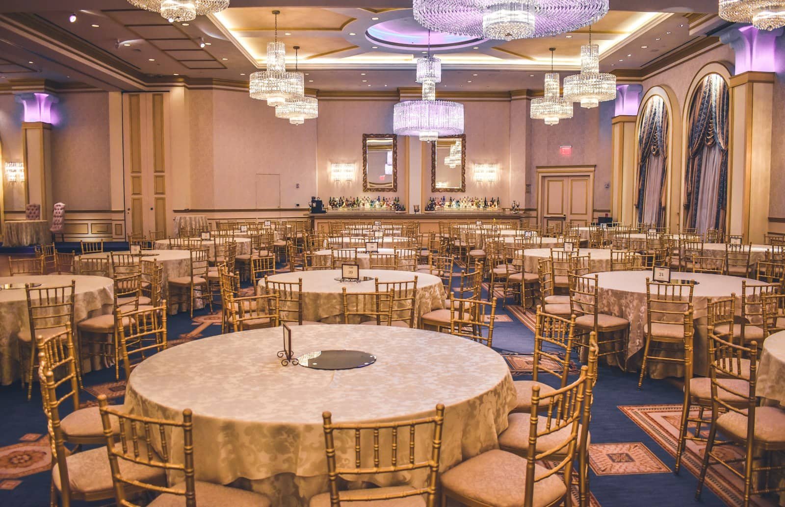 Salón de eventos montado con mesas redondas